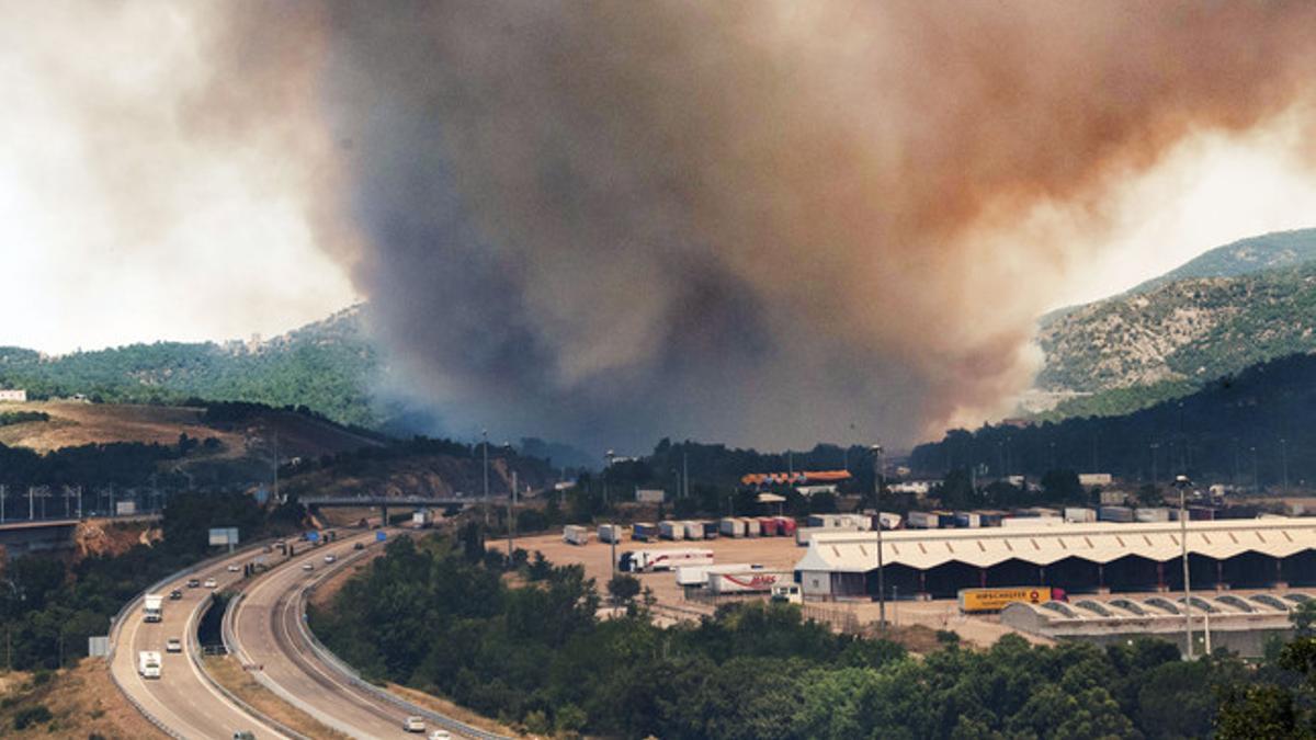 Columna de humo sobre La Jonquera, a la altura de la AP-7, el domingo.