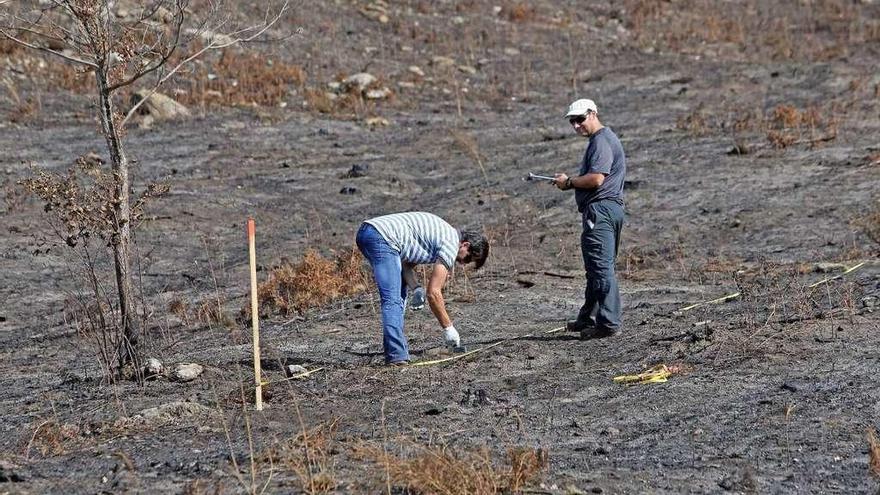 Dos técnicos inspeccionan un terreno quemado para intentar evitar la erosión.