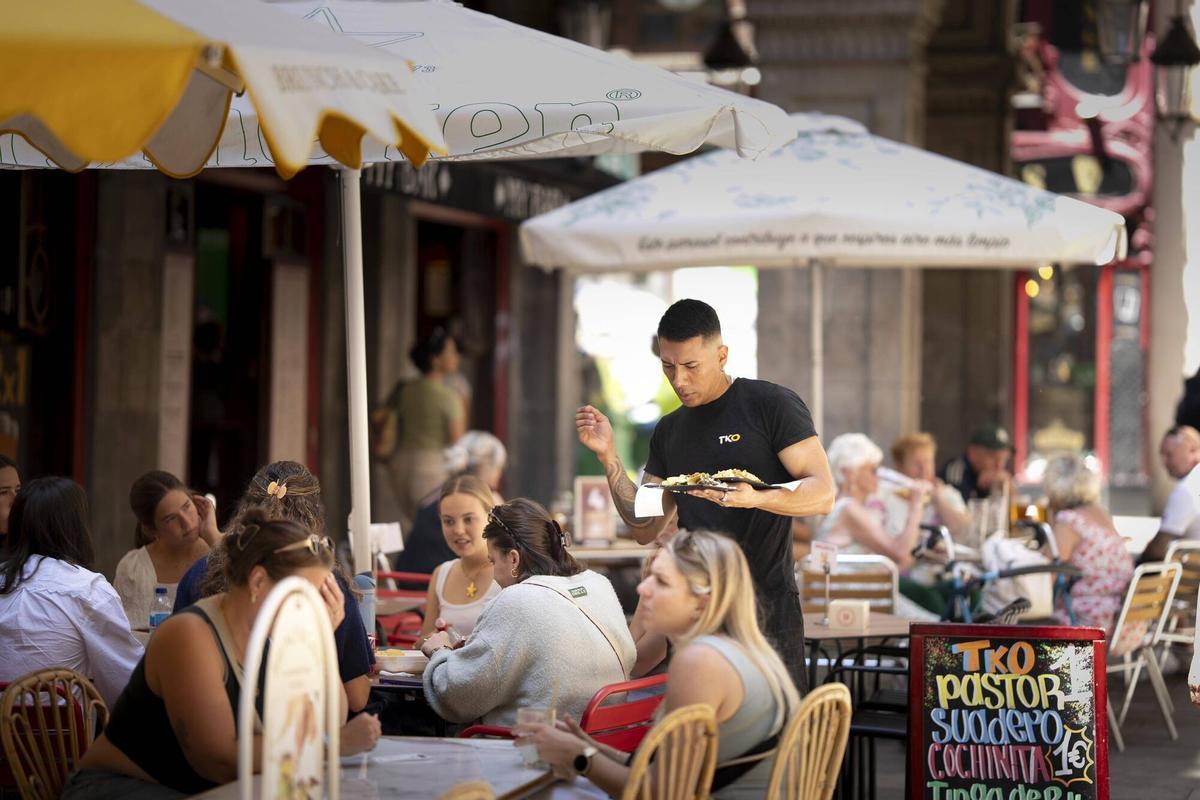 Image de archivo de un camarero trabajando en la terraza de un bar.