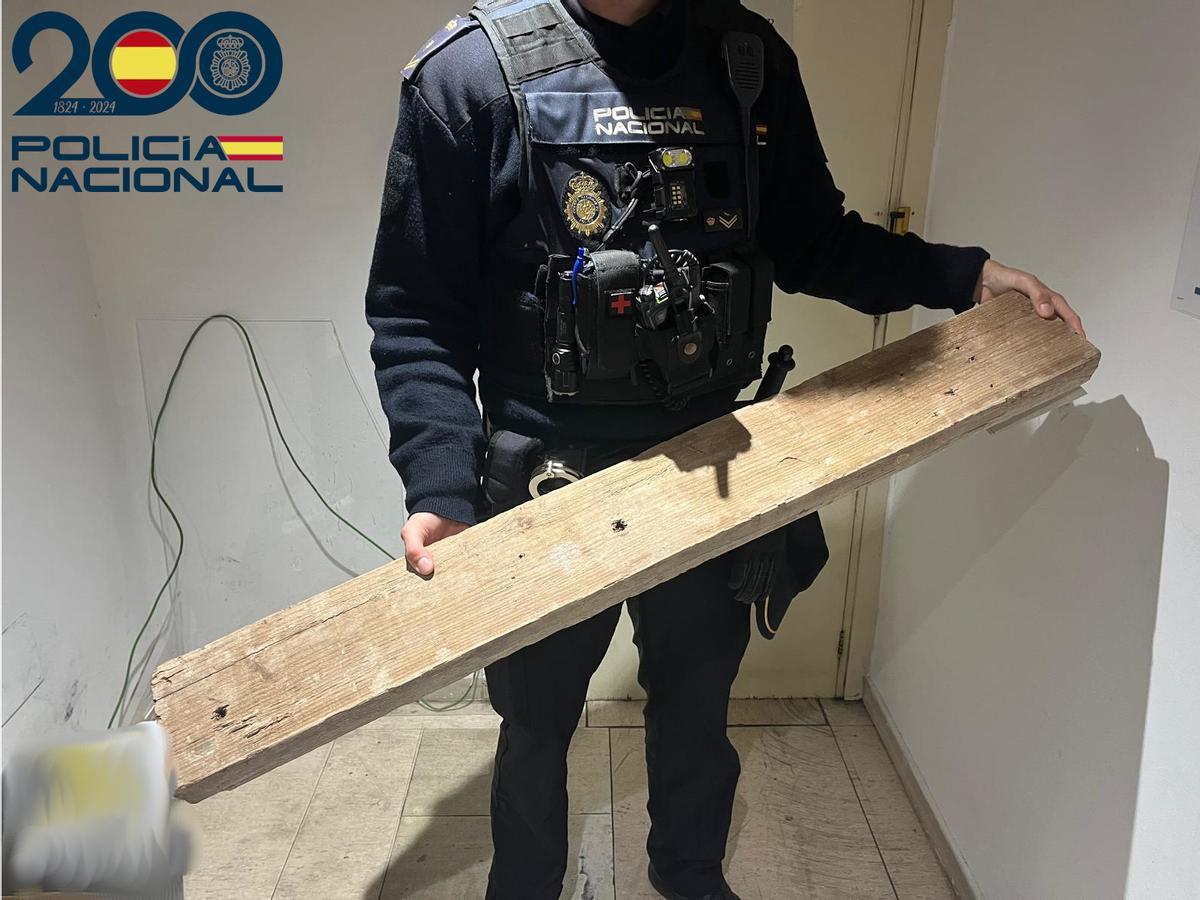 Un policía, con el tablón de madera que llevaba el detenido.