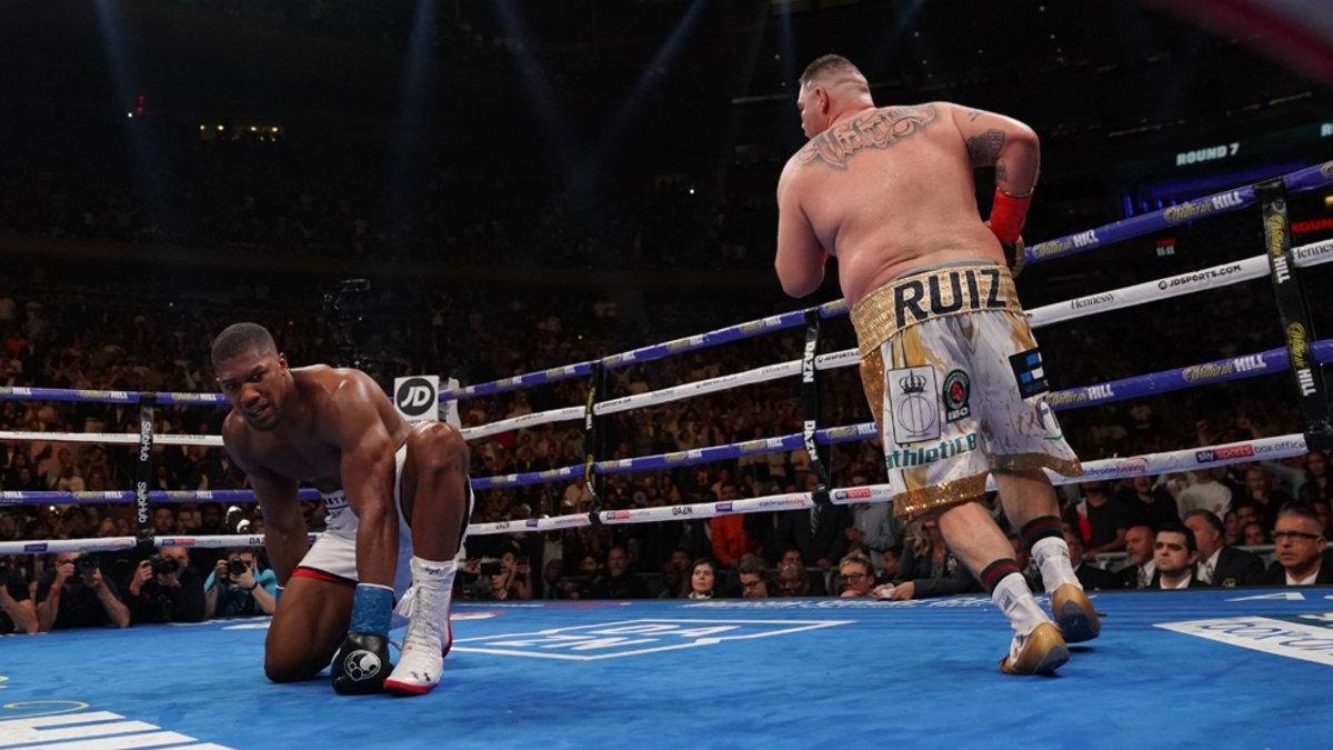 Anthony Joshua (i) se arrodilla después de ser derribado por Andy Ruiz (d).