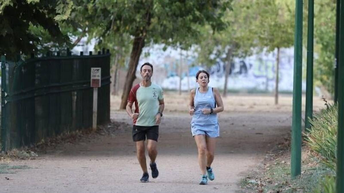 Un hombre y una mujer corriendo en un parque de Córdoba ayer.