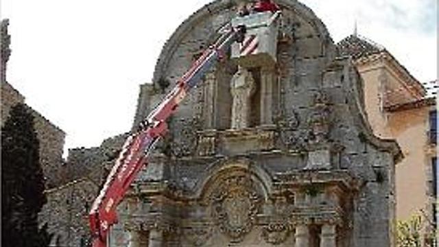 Els estudiants analitzen el monument ajudats d'una grua amb cistella.