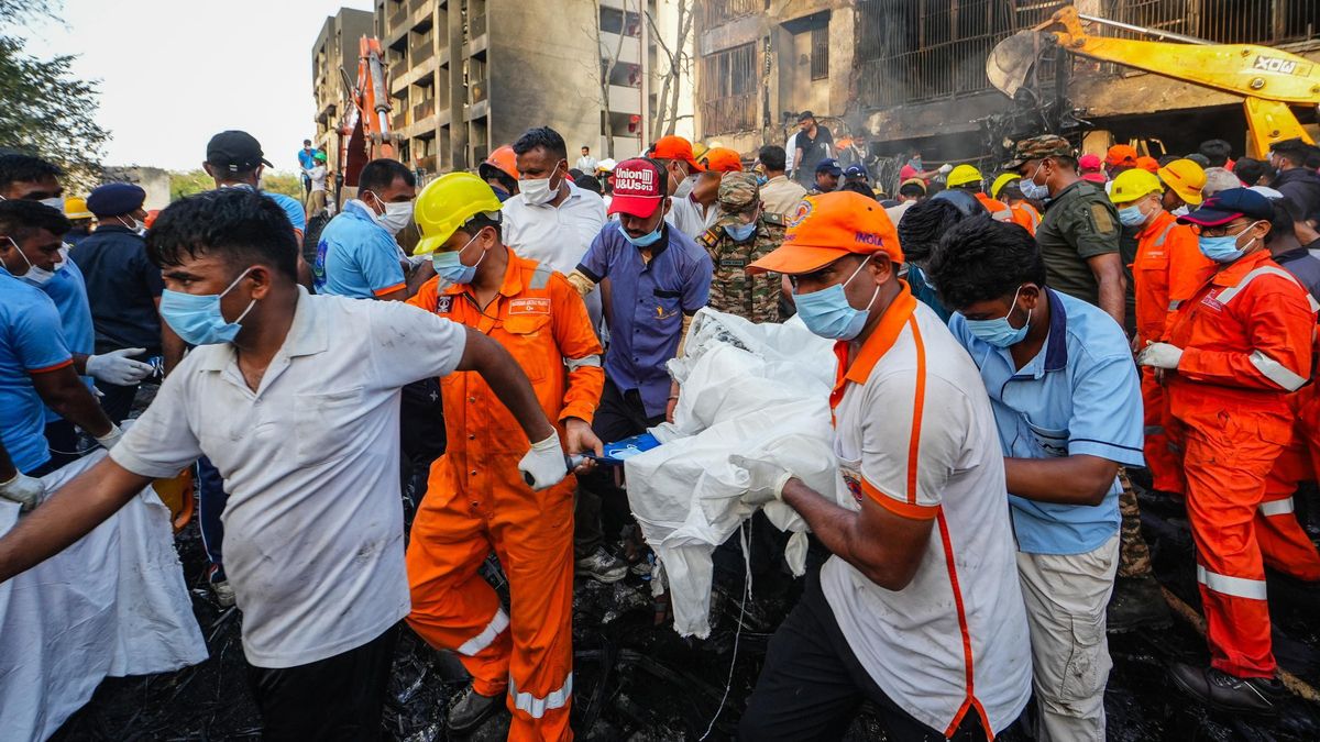 Un grupo de personas traslada a una de las víctimas del vuelo de Air India siniestrado.