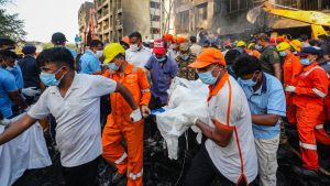 Un grupo de personas traslada a una de las víctimas del vuelo de Air India siniestrado.