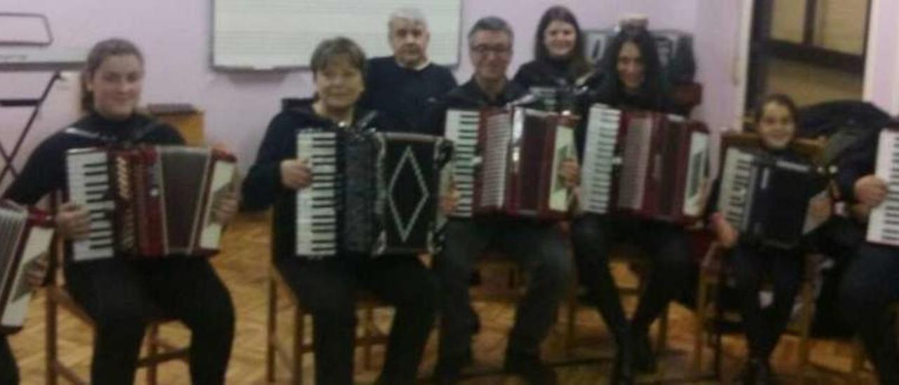 Alumnos de las clases de acordeón junto a su profesora, Rocío Mosquera, en un aula de la escuela.