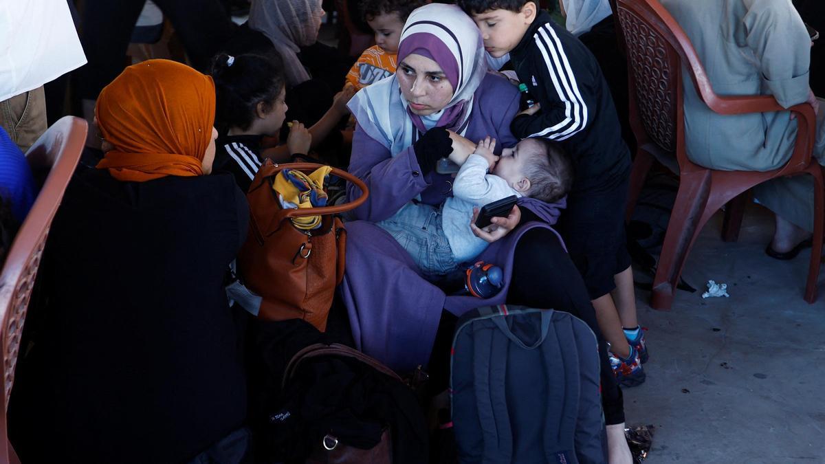 Palestinos con doble nacionalidad esperan en el cruce de Rafah a pasar a Egipto, este lunes.