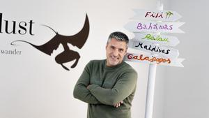 Lluís Masuet posa entre las señales paradisiacas de su agencia.