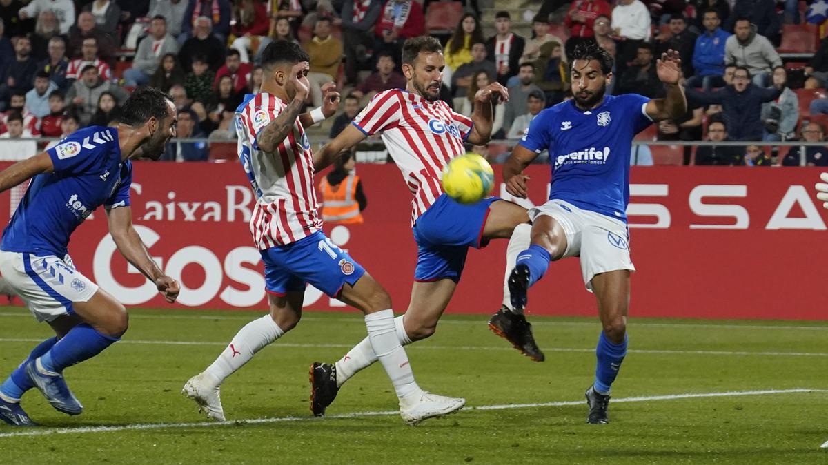 Stuani i Bustos intenten rematar una pilota davant la presència de Mellot i Carlos Ruiz (Tenerife)