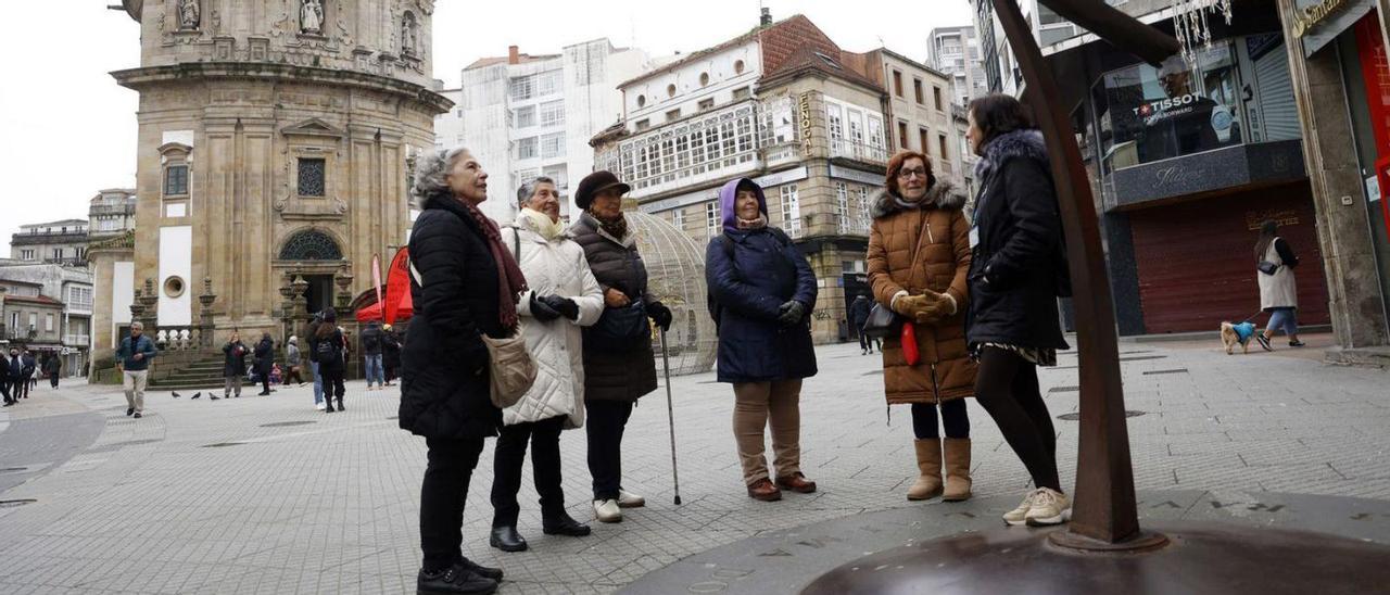 Turistas canarias ante el Santuario de la Peregrina y  la estatua de Ravachol, esta semana.