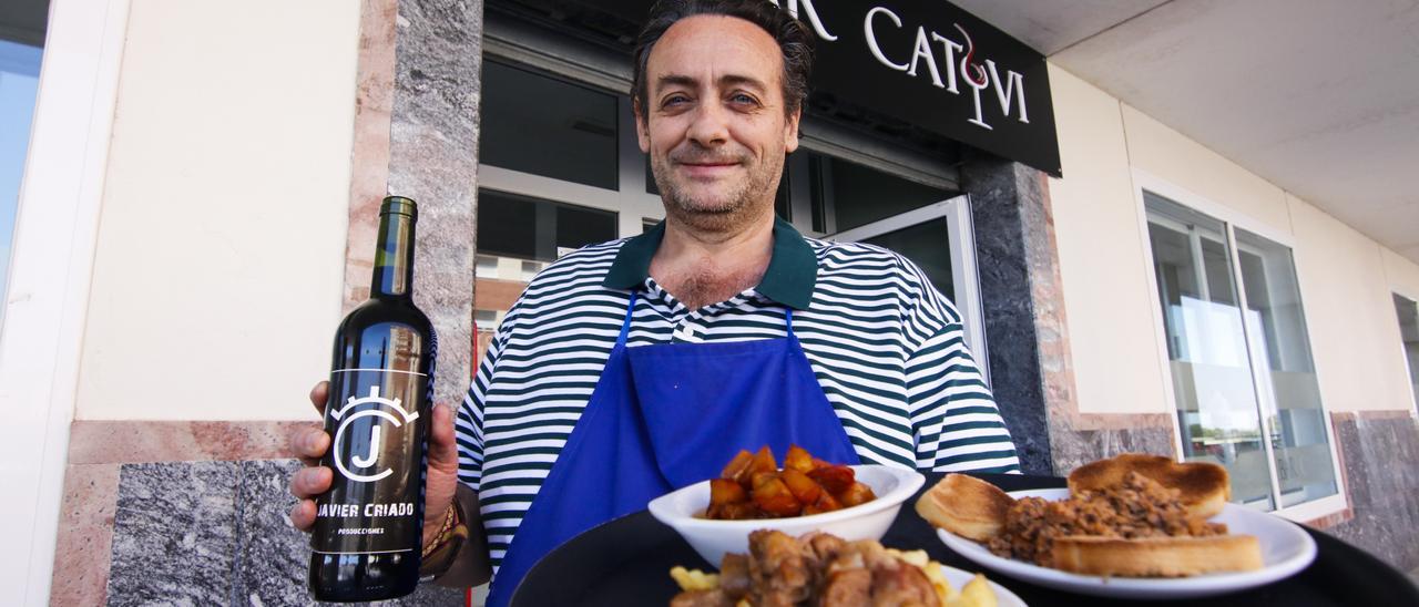 Javier Criado posa a las puertas del Bar Catovi con su vino y sus pinchos.