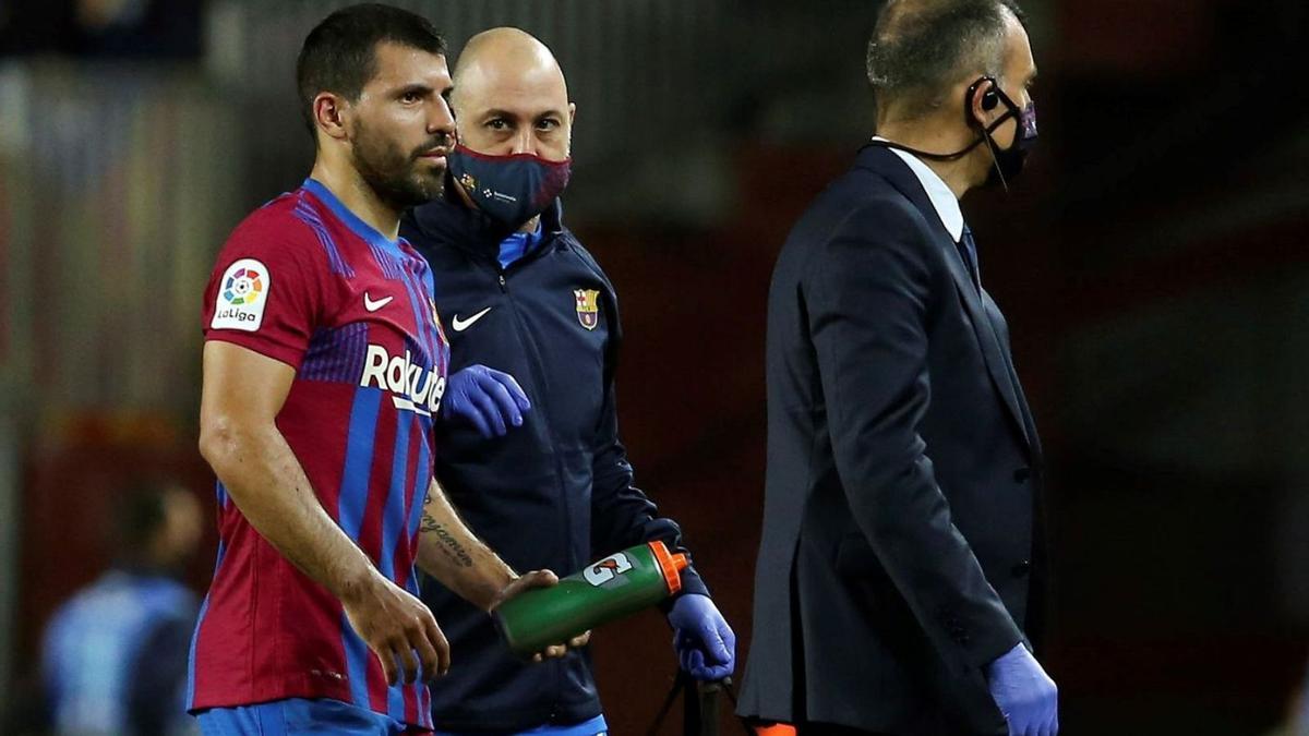 Kun Agüero se retira del campo con los doctores del Barça antes de ser trasladado al hospital. |  // EFE