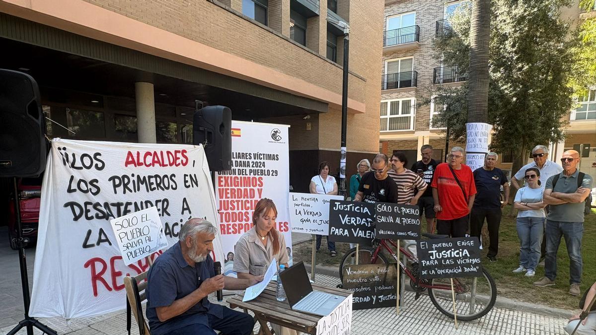 Concentración con altavoces de los segudiores de una familiar que pone en duda el número de víctimas y achaca la dana a ritos satánicos y geoingeniería.