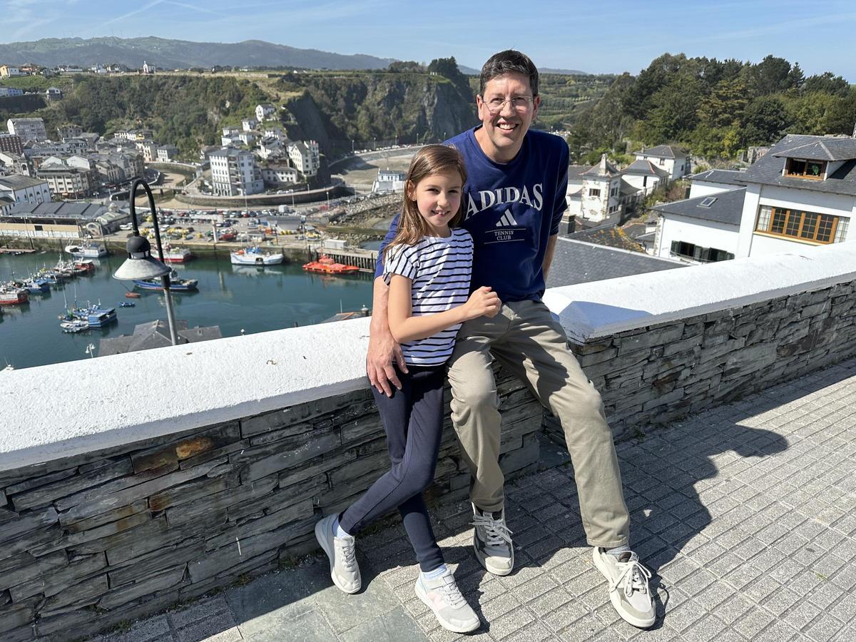 Felipe López y su hija, Emma, con Luarca al fondo.