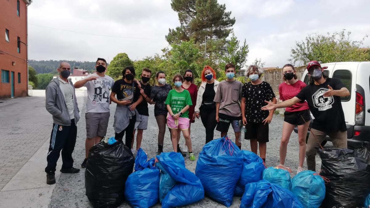 Los jóvenes de La Estación con los restos de botellón retirado del parking y de la robleda existentes en la parte posterior del Teatro Principal de A Estrada.