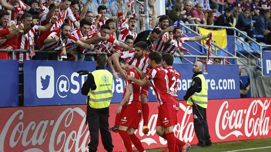 Los futbolistas celebran un gol con la afición, un joven seguidor rojiblanco y los aficionados durante un partido en El Molinón