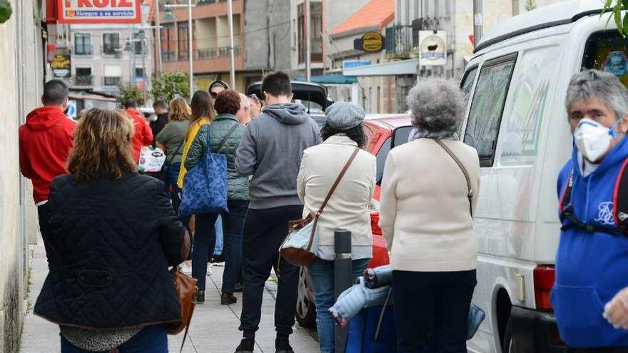 El confinamiento origina colas, cada mañana, en el entorno de los supermercados de Moaña. // G.N.