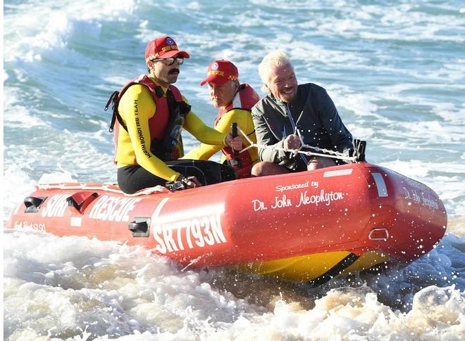 El empresario británico Sir Richard Branson (R) llega en un bote Surf Lifesaver para unirse a una clase de Pilates en Bondi Beach en Sydney, Australia.