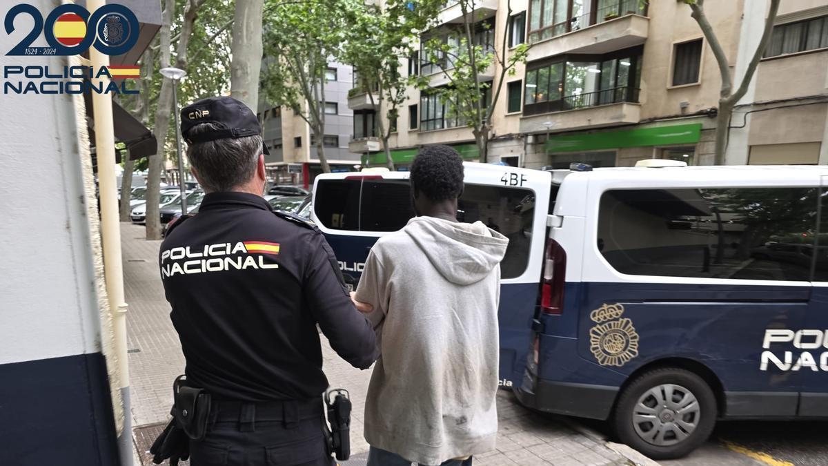 Un agente de Policía custodia al detenido camino del juzgado de guardia de Palma.