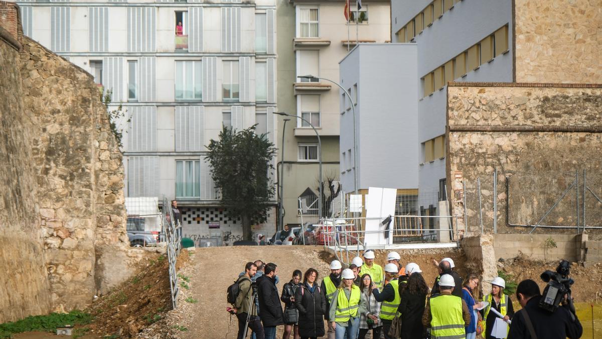 El alcalde, concejales, técnicos y prensa junto a la brecha de la muralla en la calle Hermanos Merino.