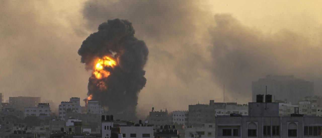 Fuego y una columna de humo tras un bomberdeo israelí sobre Ciuda de Gaza.