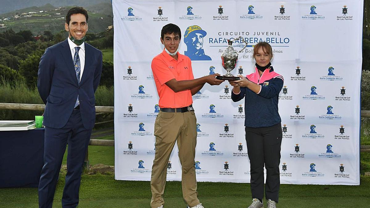 El golfista grancanario Rafael Cabrera Bello, junto a David Vega y Keira González, que alzan su premio, ayer en Bandama.