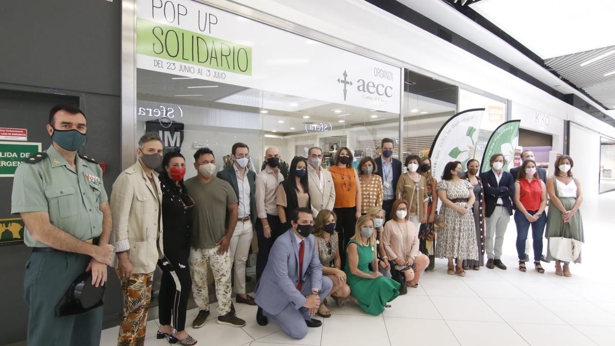 Foto de familia de todos los colaboradores y cargos que han ido a apoyar la tienda solidaria de la AECC