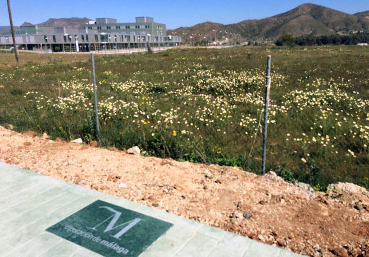 Una placa de la Diputación de Málaga, en la acera de la vía que da acceso al hospital.