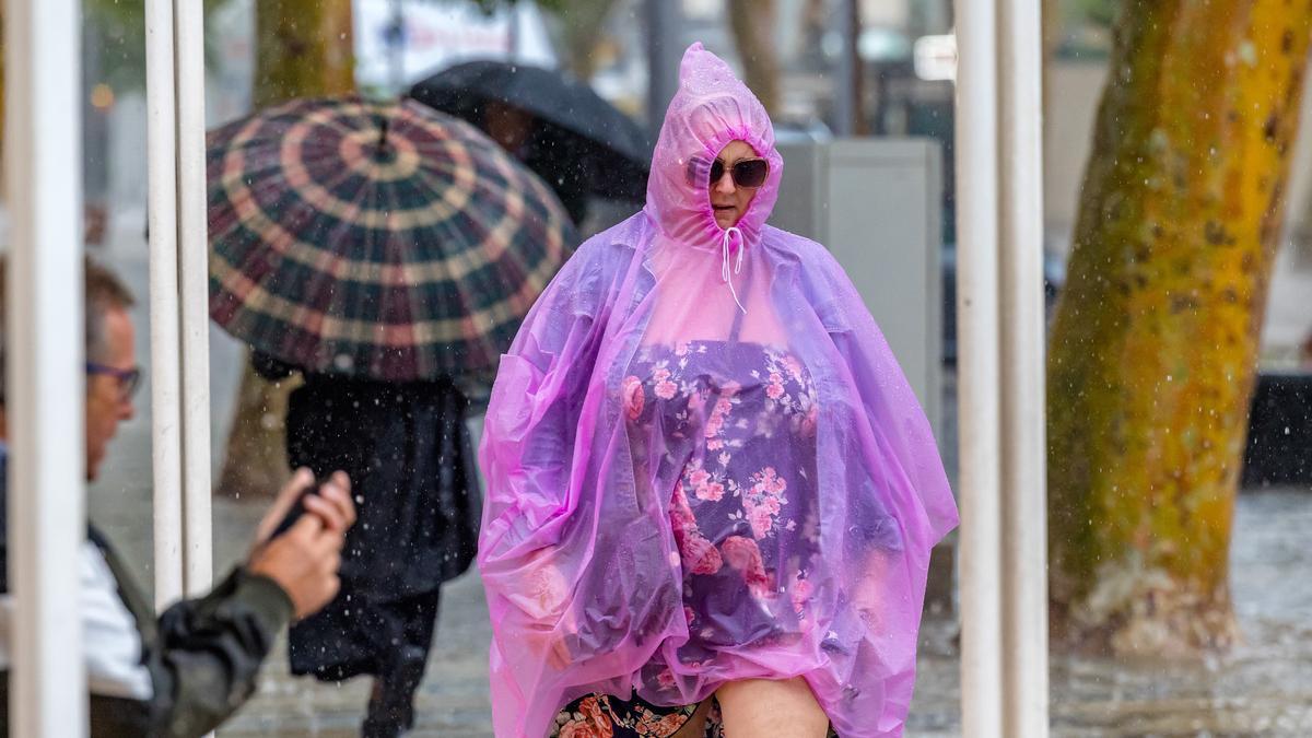 Una mujer se cubre de la lluvia en Benidorm en una imagen reciente
