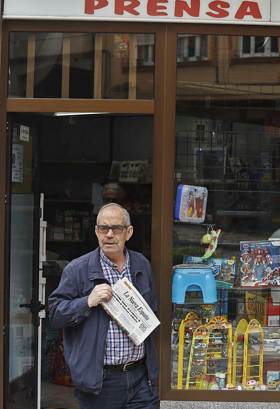 Un hombre sale con un ejemplar de LA NUEVA ESPAÑA de un quiosco de Avilés. | M. Villamuza