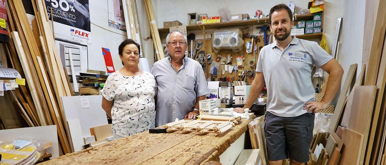 Maria, Bartolo padre y Bartolo hijo junto a la mesa de trabajo de la tienda