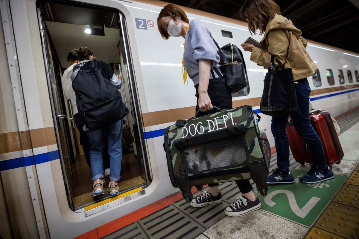 Pasajeros se disponen a embarcar en el tren bala con sus animales de compañía