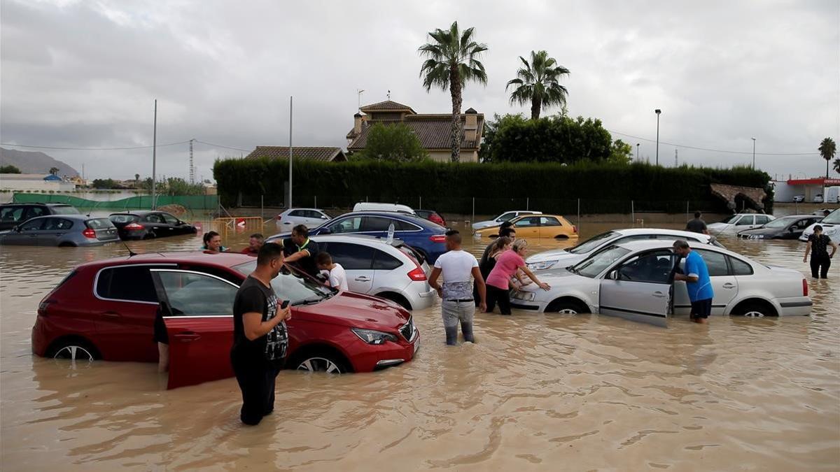 zentauroepp49840685 people stand near their cars at a partially submerged parkin190913214641
