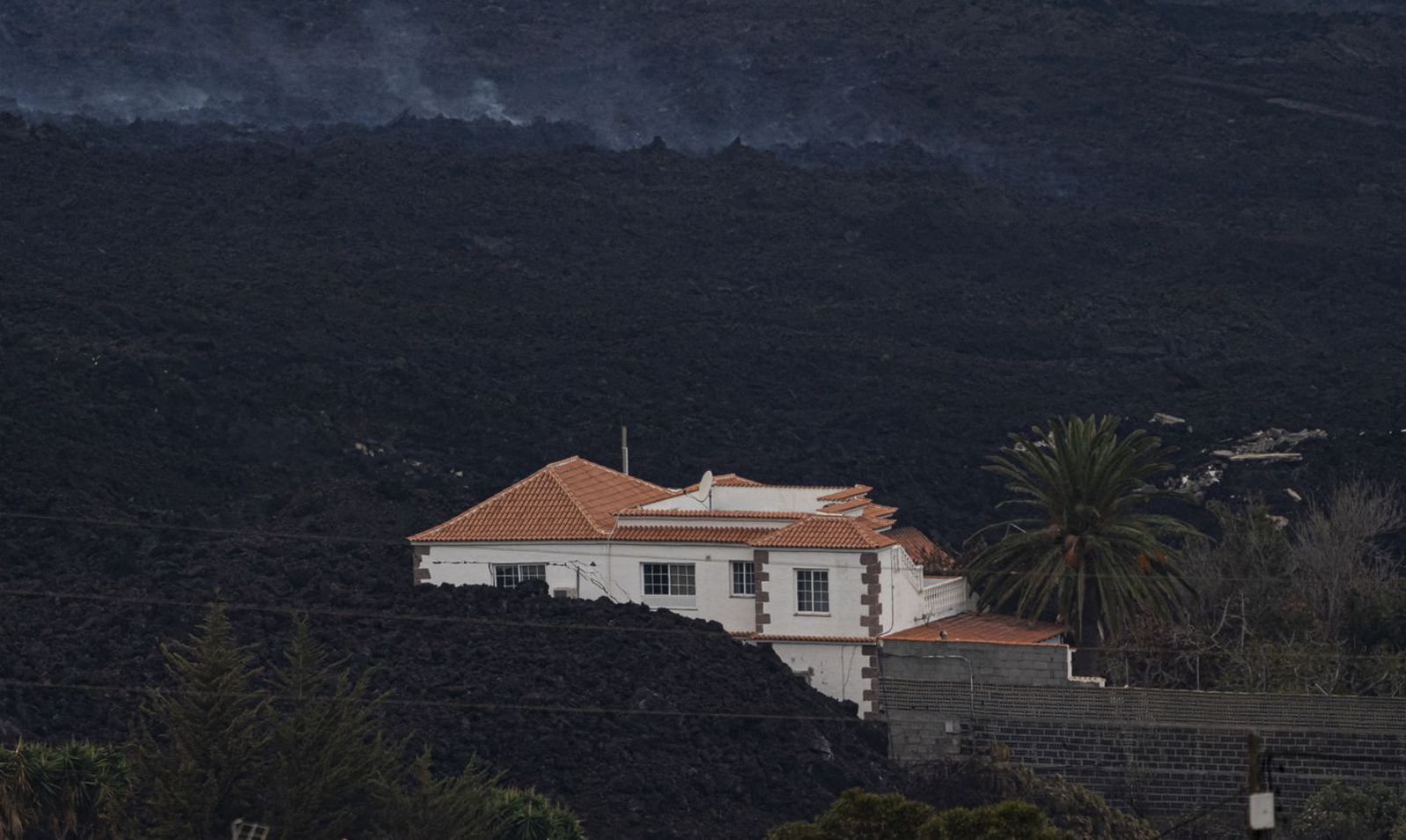 Una vivienda semicubierta por lava en La Palma.  