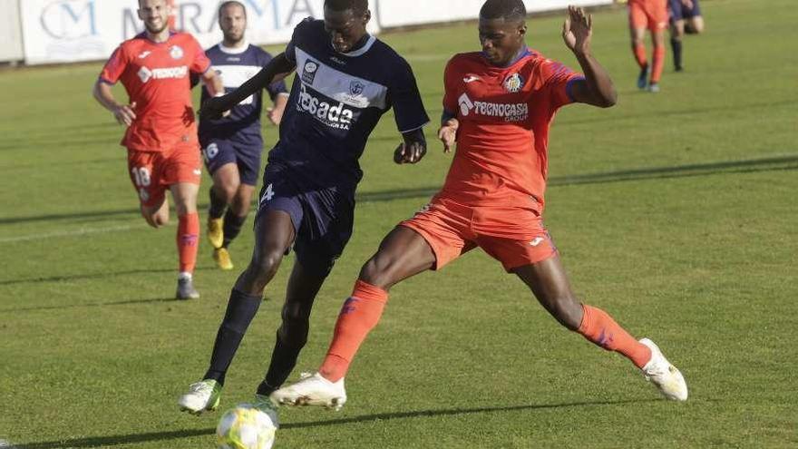 Saha, del Marino, presionado por un jugador del filial del Getafe.