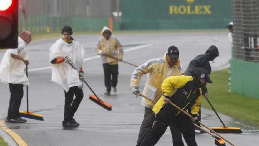 Los operarios tratan de sacar la lluvia del circuito australiano. // Efe