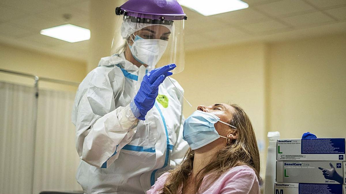 Una mujer con sospecha de Covid-19 se expone a una recogida de muestras nasofaríngea. | | ANDRÉS GUTIÉRREZ
