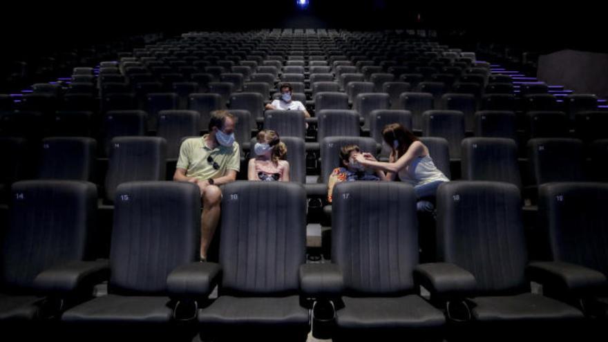 Espectadores, con mascarillas, en una sala de cine.