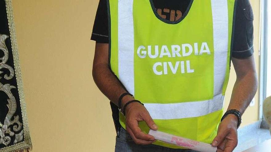 Un guardia civil muestra parte de los cartuchos intervenidos en la &quot;operación Abuelo&quot;. // Rafa Vázquez