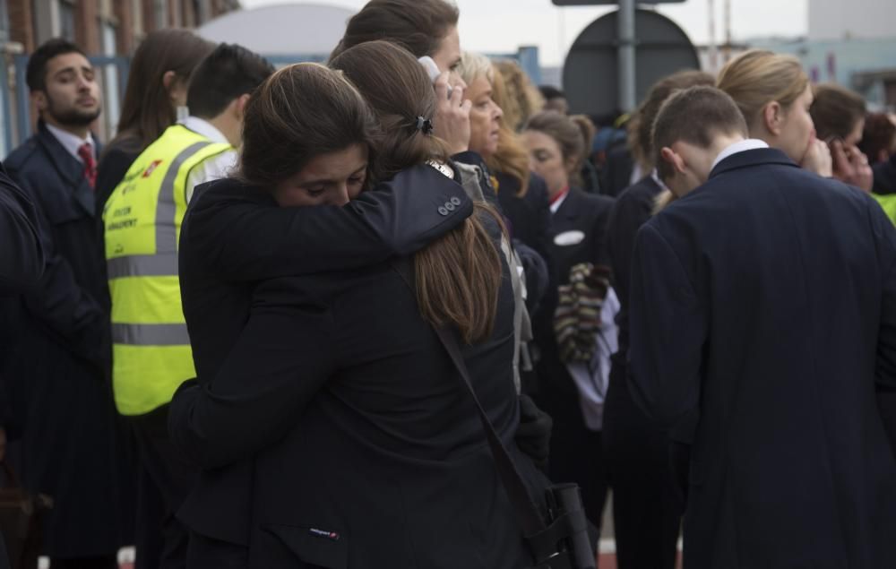 Un par de trabajadoras del aeropuerto se abrazan mientras son evacuadas junto a los pasajeros de la zona aeroportuaria tras registrarse explosiones