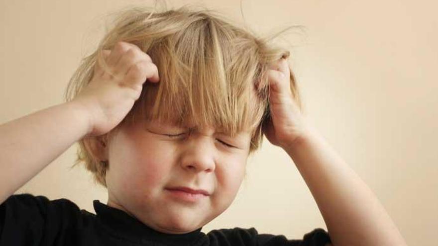 Un niño se queja por el picor de los piojos.