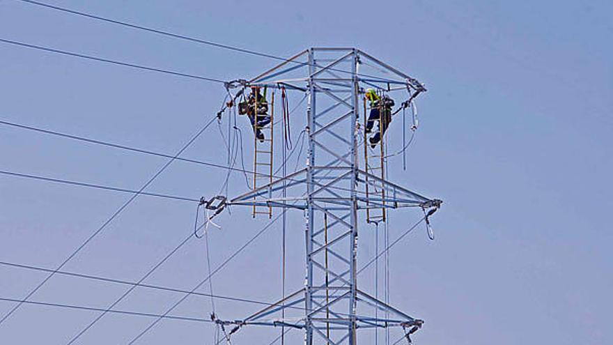 Uns operaris reparant, el maig passat, una torre d&#039;alta tensió a Sant Feliu de Guíxols.