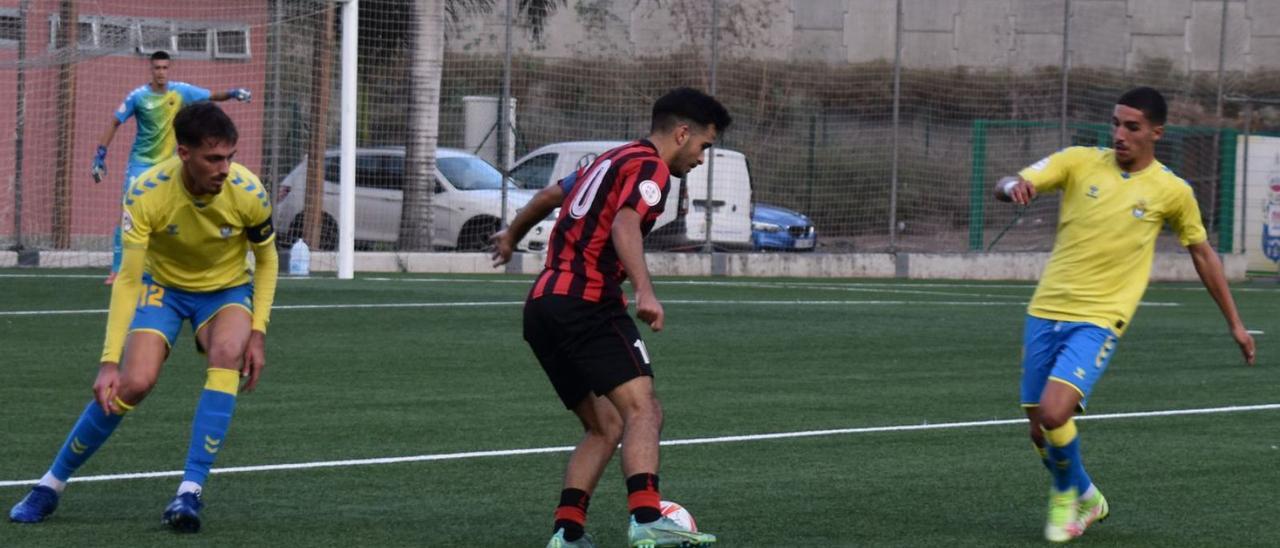 Kevin Mendoza, del Viera, controla el balón ante la mirada de Ian –izquierda– y Edian, –dch.– de Las Palmas C, ayer. | | RAMÓN REGUERO