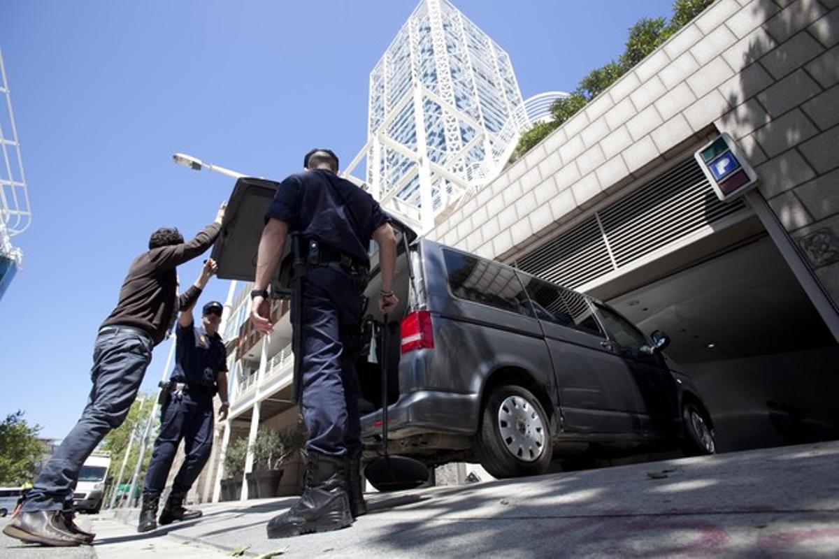 Agents de policia inspeccionen un vehicle que accedeix al pàrquing de l’establiment que acull la reunió.