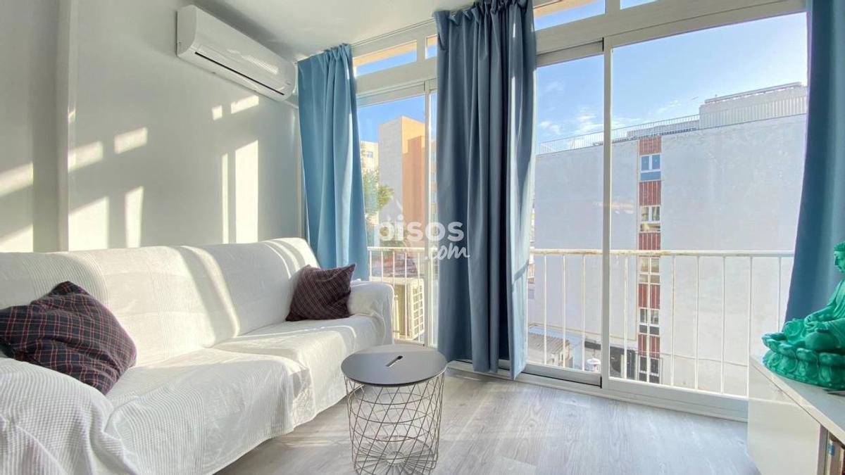 Salón luminoso con un gran ventanal y aire acondicionado en el apartamento de Magaluf