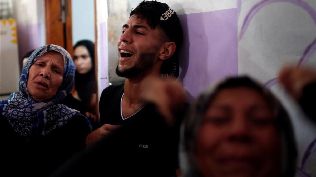 Palestinos, desgarrados por el dolor tras la muerte de unos familiares.