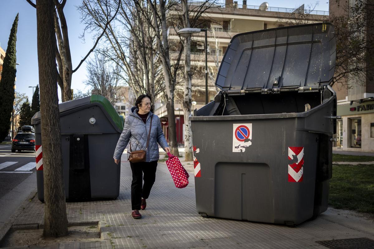 Una persona junto a un contenedor movido por el cierzo en Zaragoza
