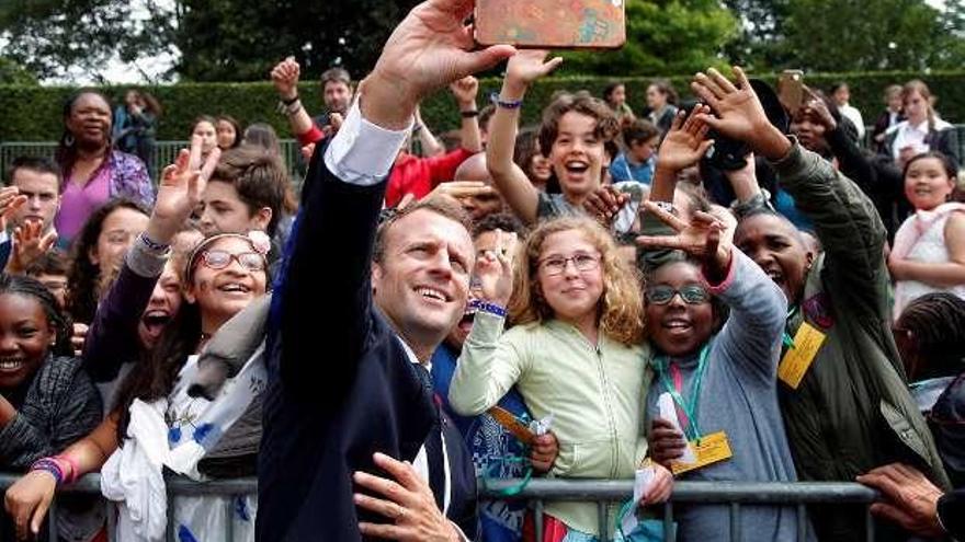 Emmanuel Macron se fotografía, ayer, con un grupo de jóvenes. // Efe