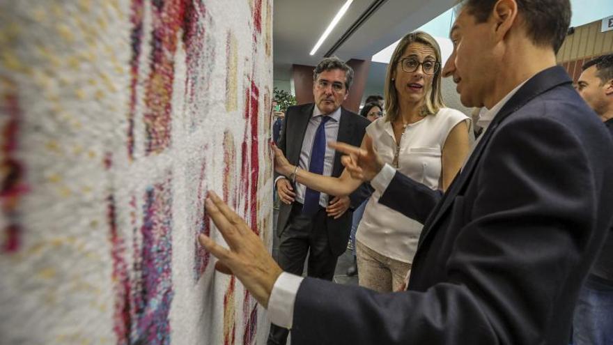 El presidente de Unifam, Eduardo Díaz, muestra una de las últimas alfombras a la alcaldesa, Lourdes Aznar.  | ANTONIO AMORÓS
