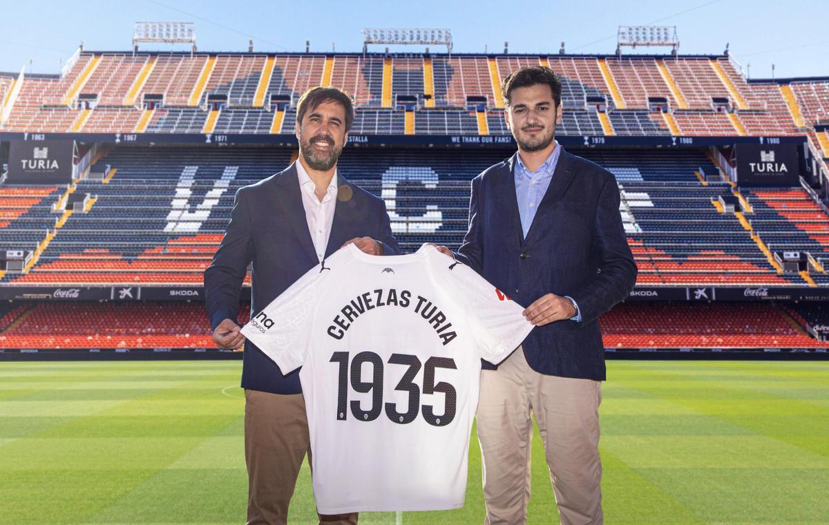 Javier Solís, director general del Valencia CF, y Ricard Gimeno, responsable de Marketing de Cervezas Turia, sobre el césped de Mestalla